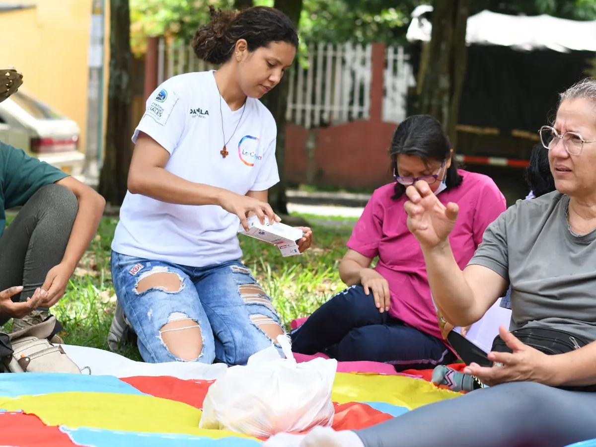 Mujeres trabajando sentadas en círculo sobre el césped