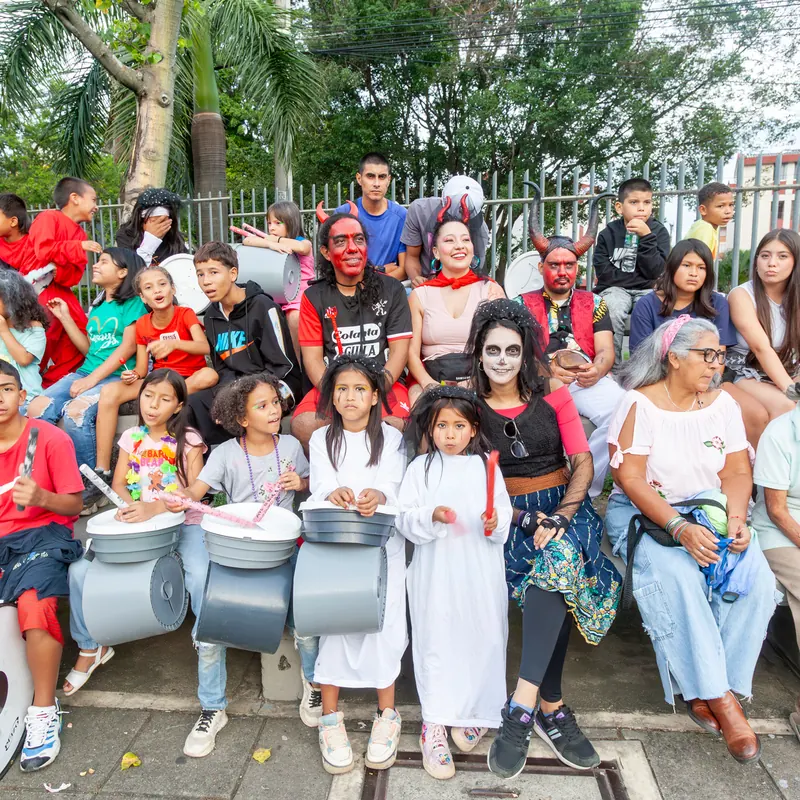 Grupo numeroso de niños, jóvenes y adultos de una comunidad, con tambores