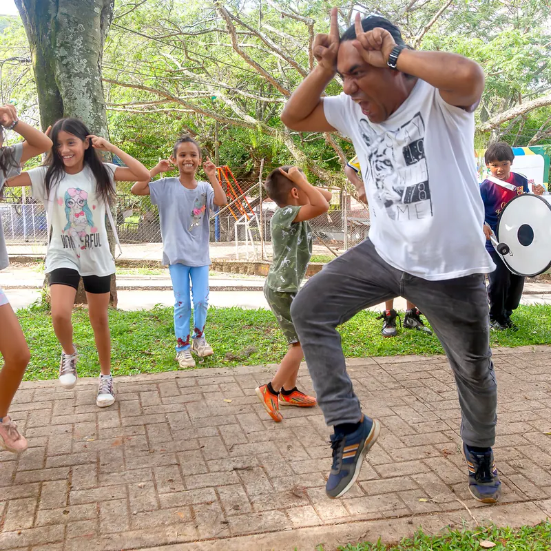 Hombre bailando con niñas y niños en un parque