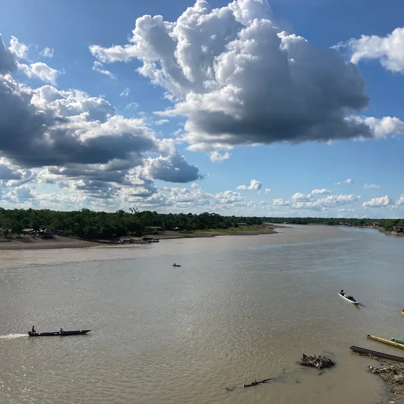 Río ancho del Pacífico con lanchas bajo un cielo de nubes