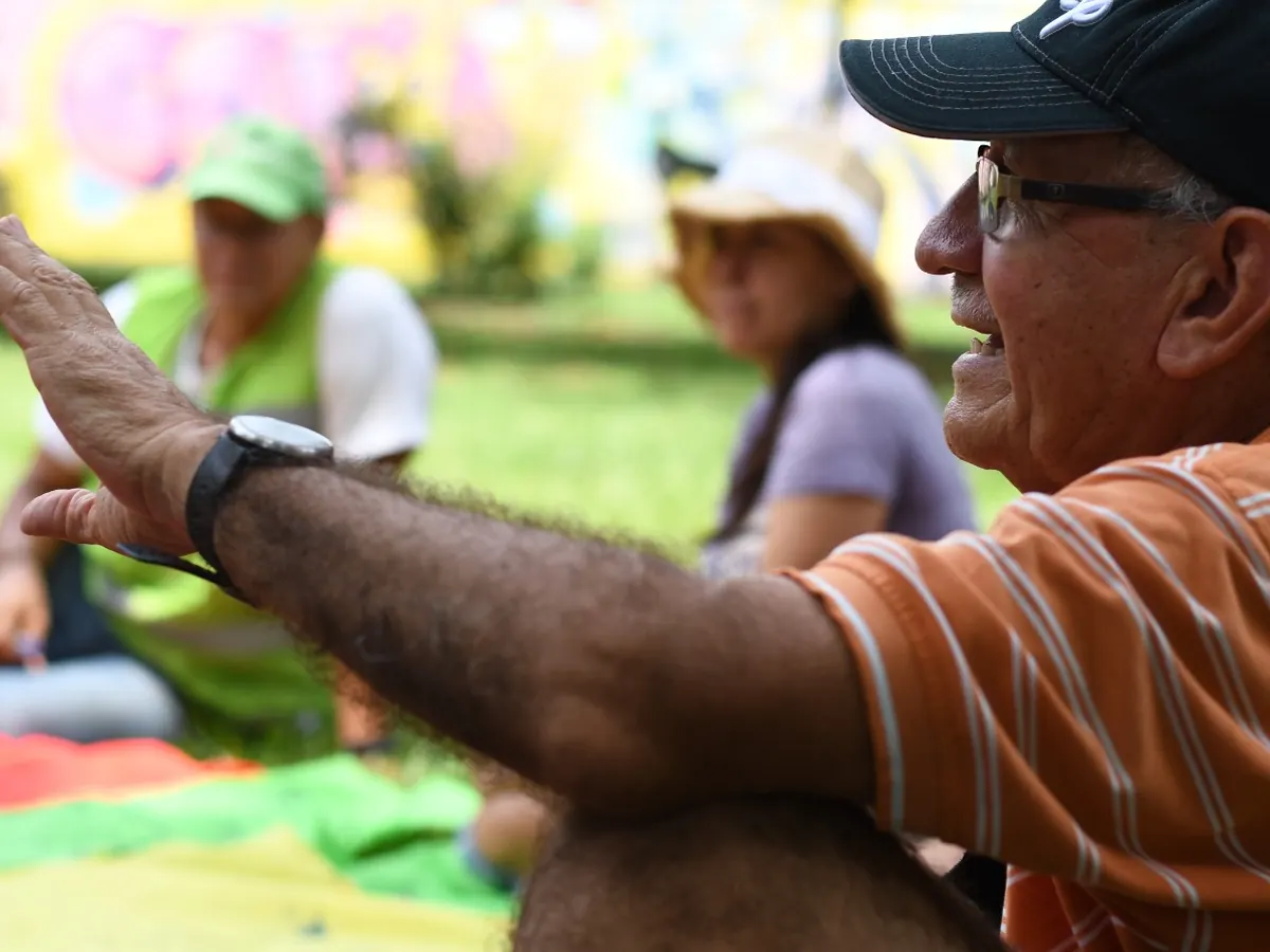 Hombre conversando y gesticulando durante una actividad en un parque